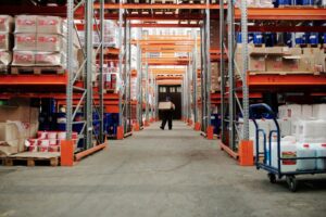 man with blue hat carrying a box in the warehouse - AMS Fulfillment
