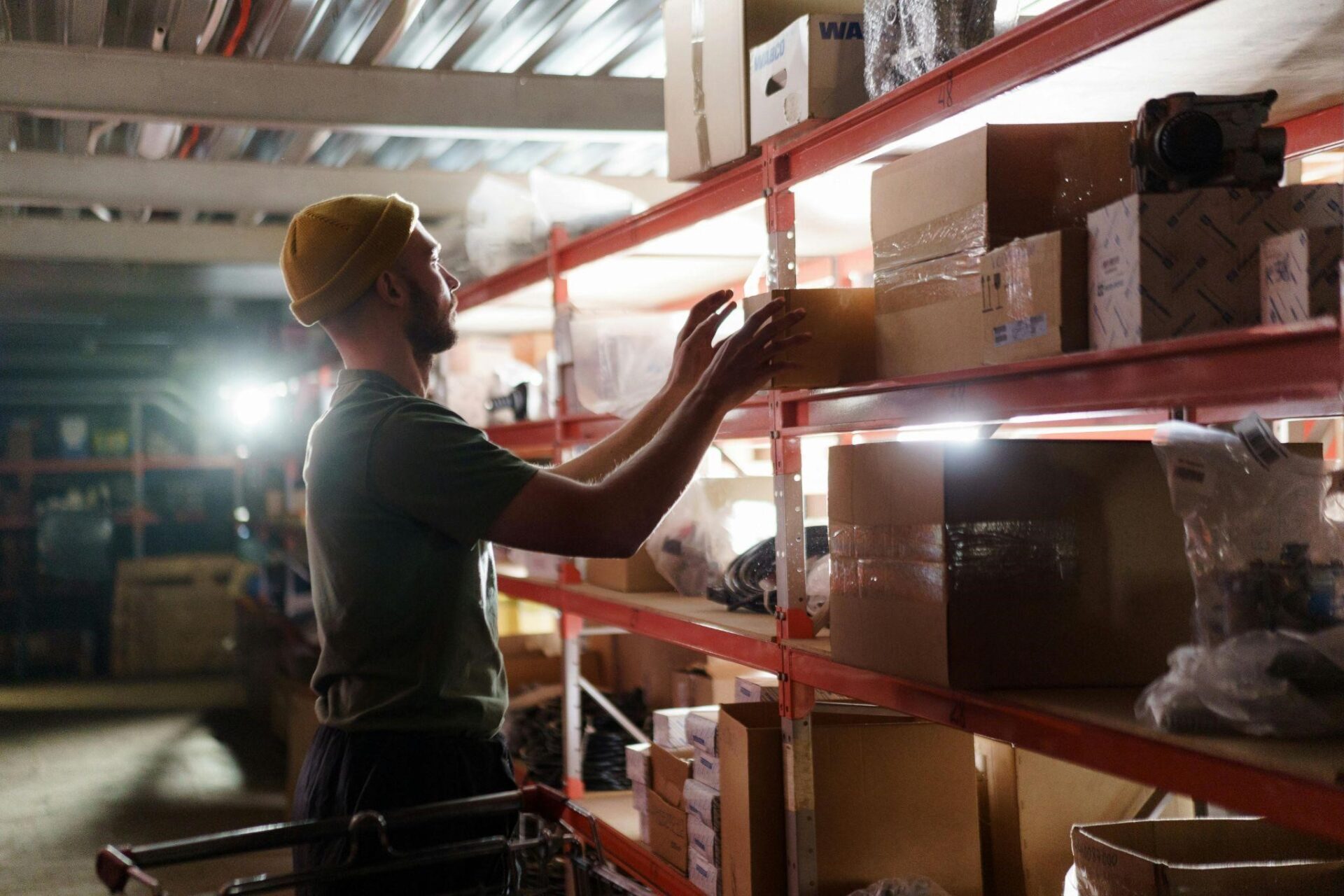 A worker pulls a box from a warehouse shelf – AMS Fulfillment