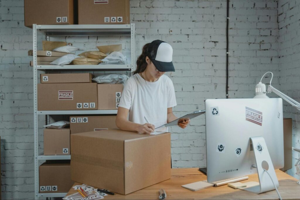 A worker fills out forms on a clipboard in a warehouse office – AMS Fulfillment