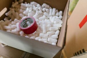 A box of packing material pellets and red tape – AMS Fulfillment